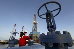 A worker checks an oil pipe at the Lukoil-owned Imilorskoye oil field outside the West Siberian city of Kogalym
