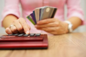 47721182 - woman calculate how much cost or spending have with credit cards