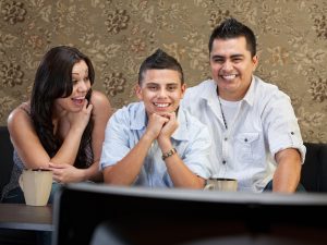 21756508 - young latino family enjoying television indoors together