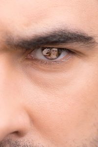 23473862 - close up of male eye. angry look, scared woman in eye reflection