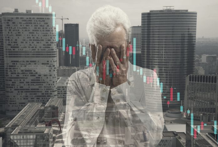 Stressed senior man holding head with hands on abstract city background. Double exposure with graphs. Virus alert, coronavirus pandemic, crisis, unemployment
