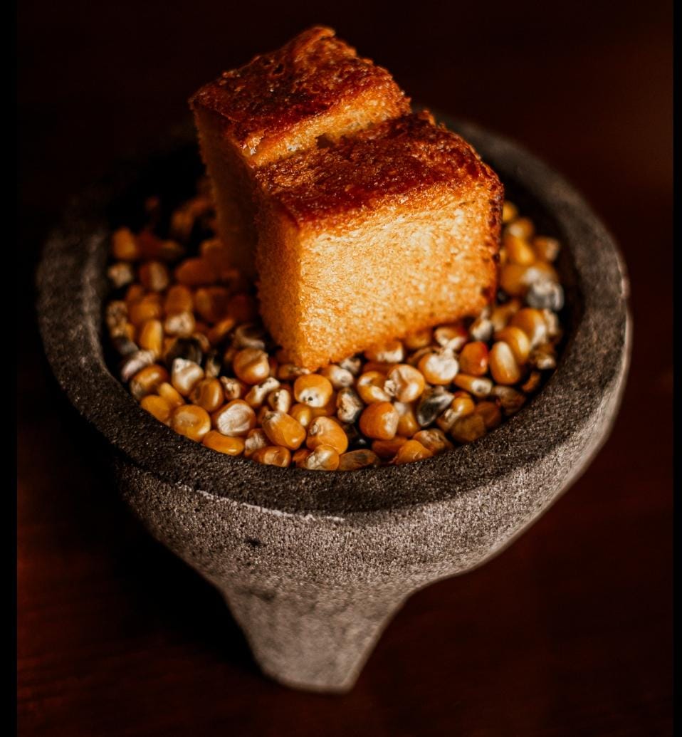 Pan brioche con harina de trigo y maíz, acompañado de mantequilla de rancho.