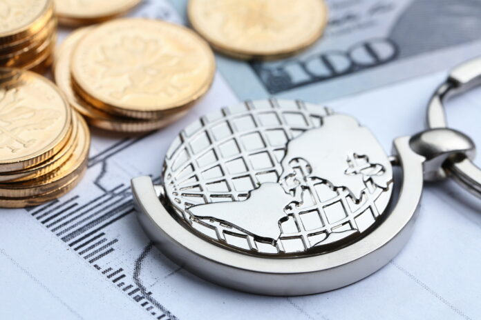 Coins, paper money and globe on white Statistic form background El organismo internacional señaló que el mejor pronóstico global derivó de la revisión al alza de Estados Unidos