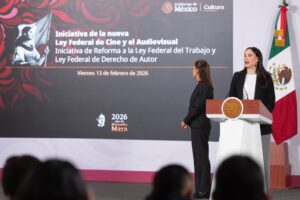La presidenta Claudia Sheinbaum defendió este viernes la desaparición de los fideicomisos en el sector cinematográfico y aseguró que el nuevo esquema de financiamiento garantiza el mismo destino de los recursos, pero con mayor transparencia y control sobre el gasto público, en el marco de un paquete de reformas que busca transformar de fondo la política audiovisual del país. Durante la conferencia matutina, la mandataria explicó que los fideicomisos eran figuras en las que, una vez depositado el recurso público —proveniente de los impuestos de la ciudadanía—, éste permanecía ahí incluso al cierre del ejercicio fiscal. “Si llega diciembre, que es cuando se cierra el presupuesto, y todavía hay recurso ahí, se queda ahí”, señaló. Detalló que, aunque los fideicomisos debían cumplir con las leyes de adquisiciones y obra pública según su naturaleza, en muchos casos no existía claridad sobre cuánto dinero permanecía acumulado en esas figuras. “No se sabía cuánto recurso finalmente estaba ahí”, sostuvo, al referirse a la falta de transparencia que motivó la eliminación de varios de estos instrumentos en años recientes. Sheinbaum subrayó que el nuevo modelo mantiene el objetivo original: financiar el fomento al cine. Sin embargo, ahora los recursos se ejercen dentro del presupuesto anual, con reglas claras y con obligación de rendir cuentas al cierre del año fiscal. “Se utiliza igual para lo mismo, exactamente para lo mismo. Y al final del año hay transparencia en el uso de los recursos y se destina todo el recurso que está destinado para el año, pero ya no queda el ‘guardadito’ que antes había, que era muy poco transparente”, afirmó. La presidenta reconoció que algunos fideicomisos se mantienen cuando tienen justificación específica, pero insistió en que en el caso del cine la prioridad es garantizar el apoyo con mecanismos abiertos y sujetos a revisión pública. El mensaje, dijo, es que el respaldo al sector no desaparece; lo que cambia es la forma de administrar el dinero: sin acumulaciones discrecionales y con mayor visibilidad sobre cada peso ejercido. Nueva Ley de Cine y reforma laboral: el contexto La defensa del nuevo esquema financiero se da en paralelo a la presentación de un paquete de iniciativas que buscan transformar el marco legal del sector audiovisual en México, fortalecer el cine nacional y proteger los derechos laborales de actores de doblaje frente al uso de Inteligencia Artificial (IA). En la conferencia “Las mañaneras del pueblo”, Sheinbaum explicó que la propuesta de nueva Ley Federal de Cine y el Audiovisual —que sustituirá a la legislación vigente desde 1992—, junto con reformas a la Ley Federal del Trabajo y a la Ley Federal de Derecho de Autor, son resultado de mesas de trabajo con productores, cineastas, actores, especialistas y autoridades culturales. “Es una iniciativa de promoción del cine nacional. Y por otro lado, está el tema del doblaje (…) la ley protege sus voces, protege su trabajo”, afirmó. La secretaria de Cultura, Claudia Curiel de Icaza, detalló que la nueva legislación amplía el ecosistema para incluir el entorno digital y a las plataformas de streaming. Entre los puntos centrales se encuentra la garantía de que al menos el 10 por ciento de la exhibición en salas corresponda a cine nacional, en mejores condiciones. Se establece una revisión semestral del cumplimiento de esta cuota y una supervisión semanal para ajustes de cartelera, además de asegurar una permanencia mínima de 14 días para las producciones mexicanas. La iniciativa también refuerza la promoción del cine nacional tanto en salas como en plataformas digitales e incorpora medidas de accesibilidad para ampliar el alcance a las audiencias. Uno de los ejes clave es el aseguramiento del presupuesto público para el fomento al cine nacional. La propuesta incorpora en la ley el Programa Fomento al Cine Mexicano (FOCINE) y garantiza un incremento en los recursos destinados al sector, privilegiando particularmente al cine independiente y a producciones en lenguas originarias. Sheinbaum subrayó que durante años parte del presupuesto se destinó a películas comerciales con financiamiento propio, por lo que ahora se priorizará a proyectos que carecen de respaldo financiero privado. “¿Cuándo habíamos visto en una película hablar en maya o en cualquier otra lengua?”, cuestionó, al destacar la diversidad creativa del país. Asimismo, se establece una política nacional de archivo para documentar, preservar, restaurar, digitalizar y difundir el acervo patrimonial que integra la memoria audiovisual de México, como parte de una estrategia para consolidar la identidad cultural en la era digital. Protección de la voz frente a la IA En paralelo, la reforma a la Ley Federal del Trabajo y a la Ley Federal de Derecho de Autor reconoce la voz humana como herramienta artística, única e irrepetible, que forma parte de la imagen de la persona y cuyo uso requerirá autorización expresa e informada cuando se empleen herramientas de Inteligencia Artificial. La propuesta establece sanciones para el uso no autorizado de voces, garantiza contrataciones justas y transparentes, y crea mecanismos ágiles de resolución de controversias ante el Instituto Nacional del Derecho de Autor (INDAUTOR). La directora general del Instituto Mexicano de Cinematografía (IMCINE), Daniela Elena Alatorre Benard, señaló que con este paquete el Gobierno se acerca a toda la cadena de producción cinematográfica: desde el desarrollo del guion hasta la preservación de las obras, y destacó que actualmente existen 14 convocatorias activas para fomentar la producción en distintos sectores. Finalmente, la presidenta adelantó que el próximo domingo se darán a conocer nuevos estímulos a la industria cinematográfica, en compañía de la actriz y productora mexicana Salma Hayek, como parte de una estrategia integral que combina financiamiento transparente, fortalecimiento del cine nacional y defensa de los derechos laborales en un contexto de transformación tecnológica.